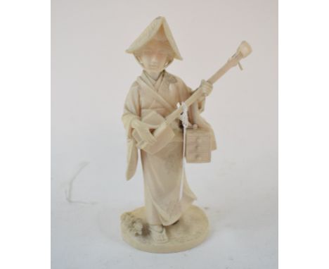 A Japanese carved ivory figure, a lady playing a musical instrument, 14.5 cm high 