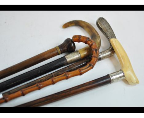 A walking stick, with lignum vitae handle, 80 cm long, and four other walking sticks (5)
