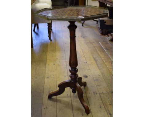 An octagonal tripod table, the top with a geometric parquetry inlay top, and a brass gallery, 50 cm wide
