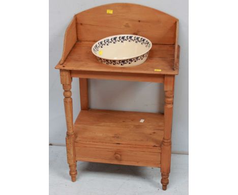 A Victorian scrubbed pine narrow wash stand by Heal & Son, London, with shaped splash back and wash bowl, with single stamped