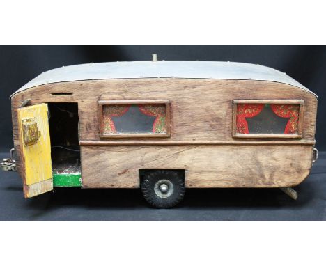 A model of a 1950 caravan, of wood construction with metal roof.
