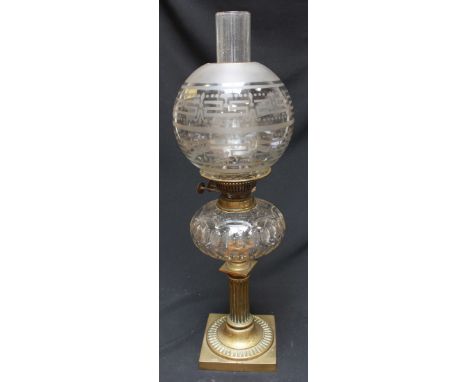A Victorian brass and glass oil lamp, with etched glass globular shade, faceted reservoir and a reeded column base. 58 cm hig