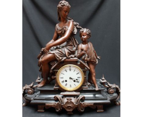 A 19th century French spelter and black marble figural mantle clock, the drum shaped movement mounted with a classical woman 