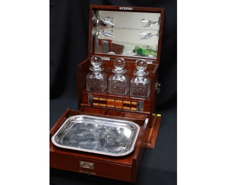 A 1920s oak drink, decanter and games compendium, the silver plated mounts, the hinged lid opening to reveal a fully fitted i