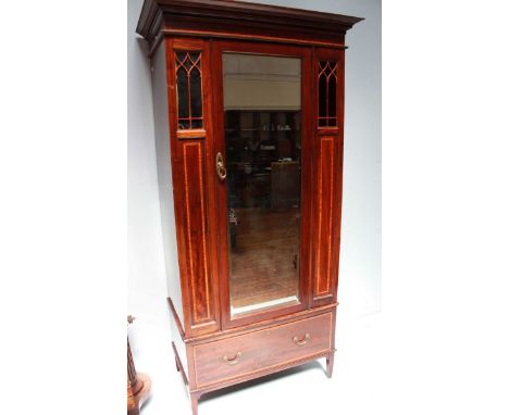 A large Edwardian mahogany single door mirrored wardrobe, with architectural open panels and satinwood inlay, supported on sh