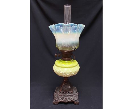 A Victorian Vaseline glass oil lamp, with Vaseline glass shade and green embossed glass reservoir, supported on a moulded bas