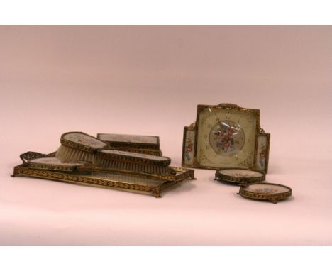 An ornate dressing table set, with needlework decoration, comprising dressing table tray, ash tray, trinket box, clock, two b