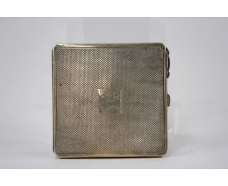 A silver compact with engine turned decoration, Birmingham 1940; 6cm x 6cm 