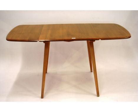 A light Ercol drop leaf dining table 70 cm high, 74cm x 139cm extended 