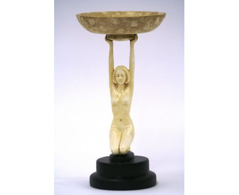 An Art Deco style model of a nude female, holding a bowl, raised on circular step base, 25.5cm