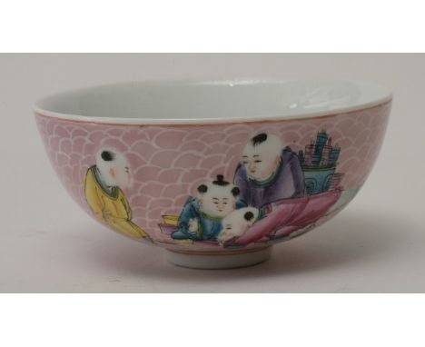 A chinese porcelain bowl in hatch pink ground painted with figures playing 110mm in diameter 