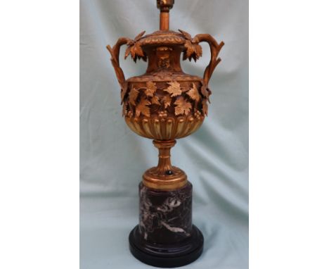 A late 19th century ormolu table lamp in the form of a two handled pedestal urn, decorated with satyr masks and trailing vine