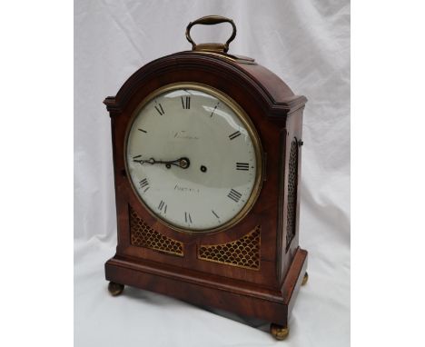 A Regency mahogany bracket clock, with a brass carrying handle above a domed top, the sides and front with gilt grilles, on a