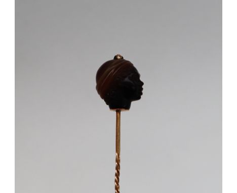 A hardstone stick pin, the top carved as a Blackamoor head with turban on a yellow metal twist decorated pin, 8.5cm long COND