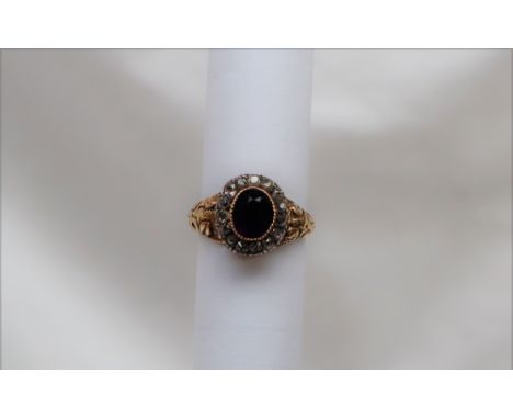 A Victorian amethyst and diamond cluster ring with a central oval faceted amethyst surrounded by diamonds in a white metal mo