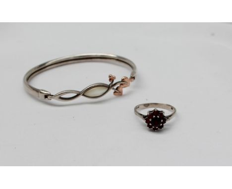 A silver, mother of pearl and yellow metal Clogau bangle together with a silver and garnet set dress ring