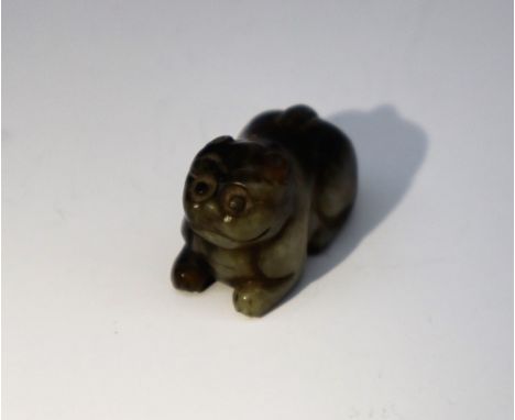 A Chinese carved jade pendant in the form of a recumbent cat, drilled with a hole for cord or wire suspension, 3cm long x 2cm