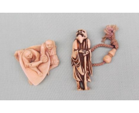 A late 19th Century ivory netsuke, in the form of a figure seated on a shell, with another by his side, 4.5cm long together w