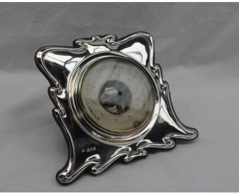 An Art Nouveau inspired silver desk barometer, with a ribbon border, with a central paper dial, Chester, William Neale, 14cm 