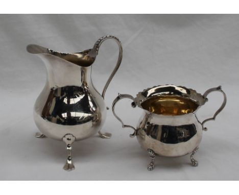 An Edwardian silver cream jug of plain baluster form, beaded S shaped handle, on three trefoil supports, 1906, maker Charles 