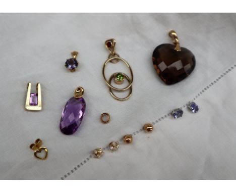 A faceted oval amethyst pendant on a 9ct gold clasp together with a heart shaped citrine pendant, three other pendants and st