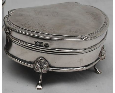 A George V silver trinket box of rounded triangular outline, moulded rim with scroll corners, on four supports, Sheffield 191