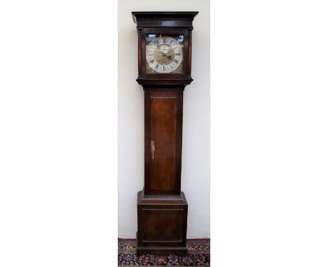 A George III mahogany long case clock, the flat hood with moulded cornice, and three quarter columns above a long trunk door 