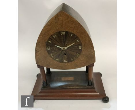 An Arts &amp; Crafts burr walnut mantel clock, centred with a rosewood dial on four pillar supports on a sloped platform base