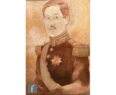 An early 20th century silk embroidered portrait depicting King Albert I of Belgium, within an ornately carved oak frame, 32cm