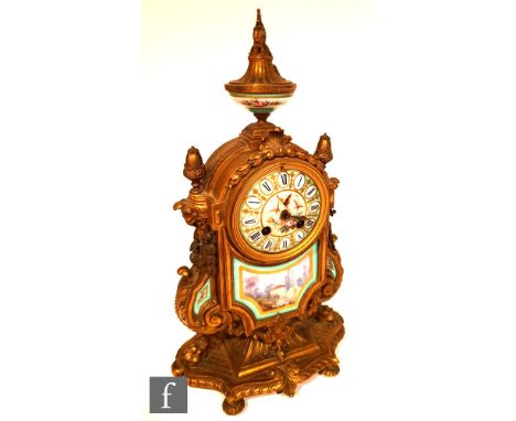 A late 19th Century gilt metal mantel clock with hand painted porcelain panels, with a floral urn finial over a dial painted 