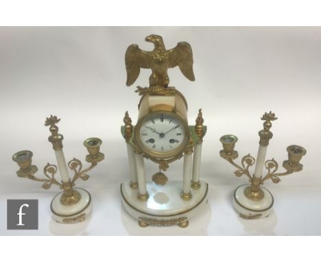 A 19th Century French white marble and gilt metal clock garniture, the portico style four pillar clock with eagle finial, whi