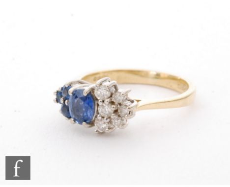 An 18ct hallmarked sapphire and diamond cluster ring, central oval sapphire flanked by three further sapphires to one side an