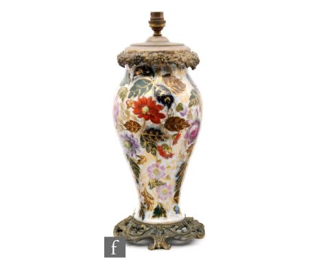 A late 19th to early 20th Century vase decorated with hand painted flower heads and foliage with gilt detailing, later conver