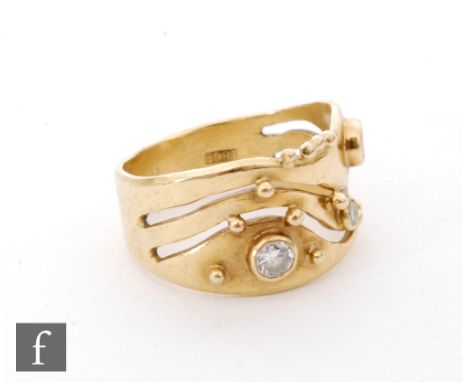 An 18ct diamond set ring, three collar set stones to a waved split head with shot details, weight 6g, ring size M. 