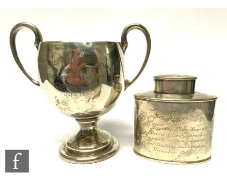 A hallmarked silver oval tea caddy together with a twin handled trophy cup, both with presentation engravings, total weight 9