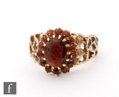 A 9ct hallmarked garnet cluster ring, oval claw set cluster to pierced shoulders, weight 5.4g, ring size R. 