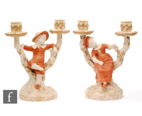 A pair of late 19th Century Royal Worcester twin branch candlesticks, modelled by James Hadley, shape 1124 and 1125, both wit