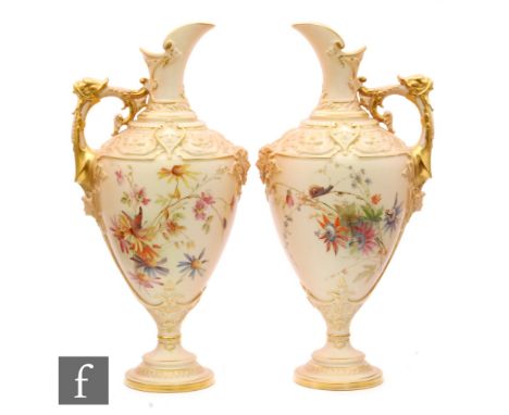 A pair of late 19th Century Royal Worcester blush ivory pedestal jugs, shape 1742, each decorated with a spray of flowers, on