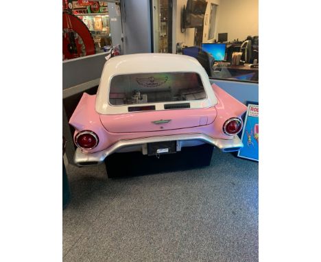 This rare jukebox has a pink 1957 Ford Thunderbird style fiberglass body with a white top that fits flush against a wall. It 