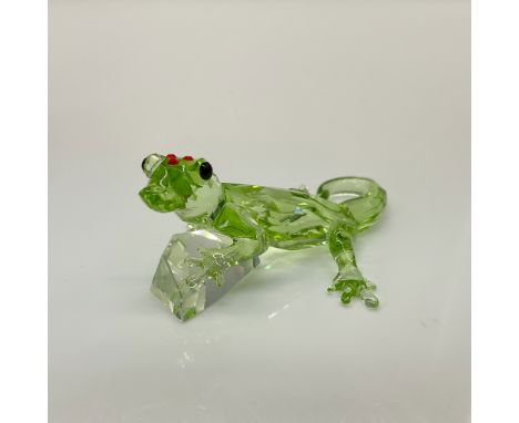 This Swarovski crystal Gecko is made from green crystal, with black eyes, and red stones on the top of his head. He is holdin