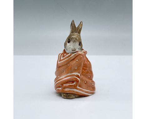 Glossy porcelain. Features a rabbit wrapped in an orange blanket. Royal Albert Beatrix Potter backstamp. This item has its or