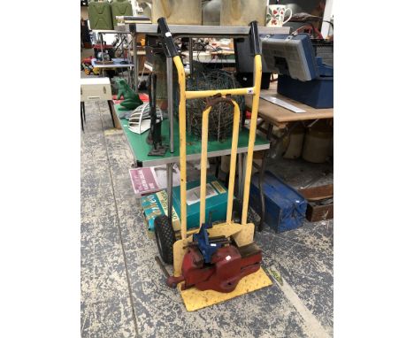 A SACK TRUCK AND TWO BENCH VICE.