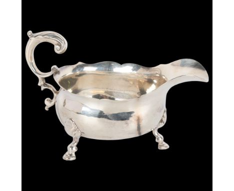 A George II silver sauce boat, indistinct maker, London 1744, bulbous form with shaped border, scrolled acanthus leaf handle,