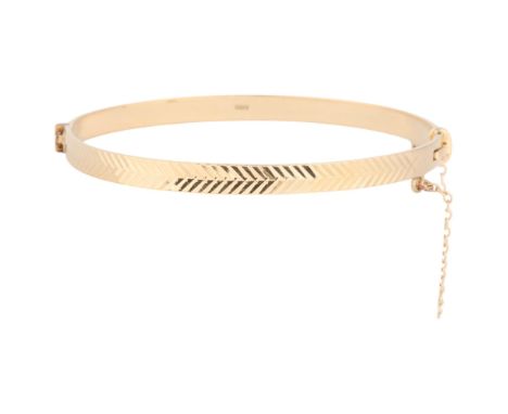 A 9ct gold hinged bangle, maker FM, London 1965, allover fluted decoration, band width 4.7cm, internal circumference 17cm, 9.