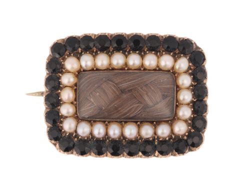 An Antique Georgian hairwork split pearl and French jet mourning brooch, circa 1820, the central woven hair panel beneath con