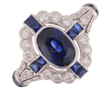 An Art Deco style 18ct white gold sapphire and diamond cluster ring, rub-over set with 1.4ct oval mixed-cut sapphire, within 