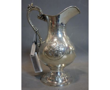 An American silver ewer, with repousse embossed vignette of flowers and vacant cartouche on an engine turned field, scroll ha