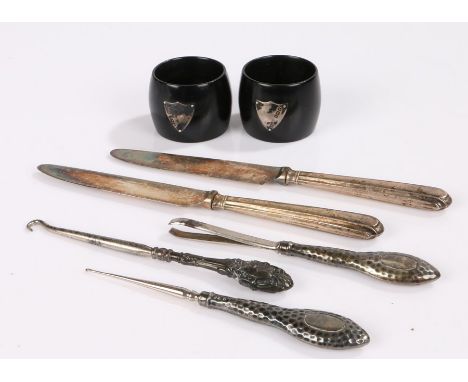 Pair of silver mounted ebony napkin rings with vacant shield shaped cartouches, pair of silver handled tea knives, two silver