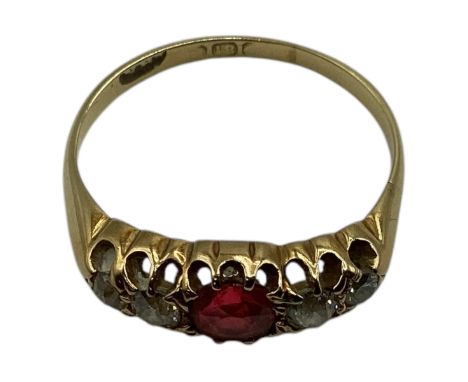 An 18ct gold ruby and diamond ring. central round free cut ruby with old cut diamond accents. Size M. 2.7g. 