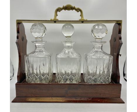 A C20th Tantalus, with moulded glass decanters and stoppers, brass top and mahogany case, with key